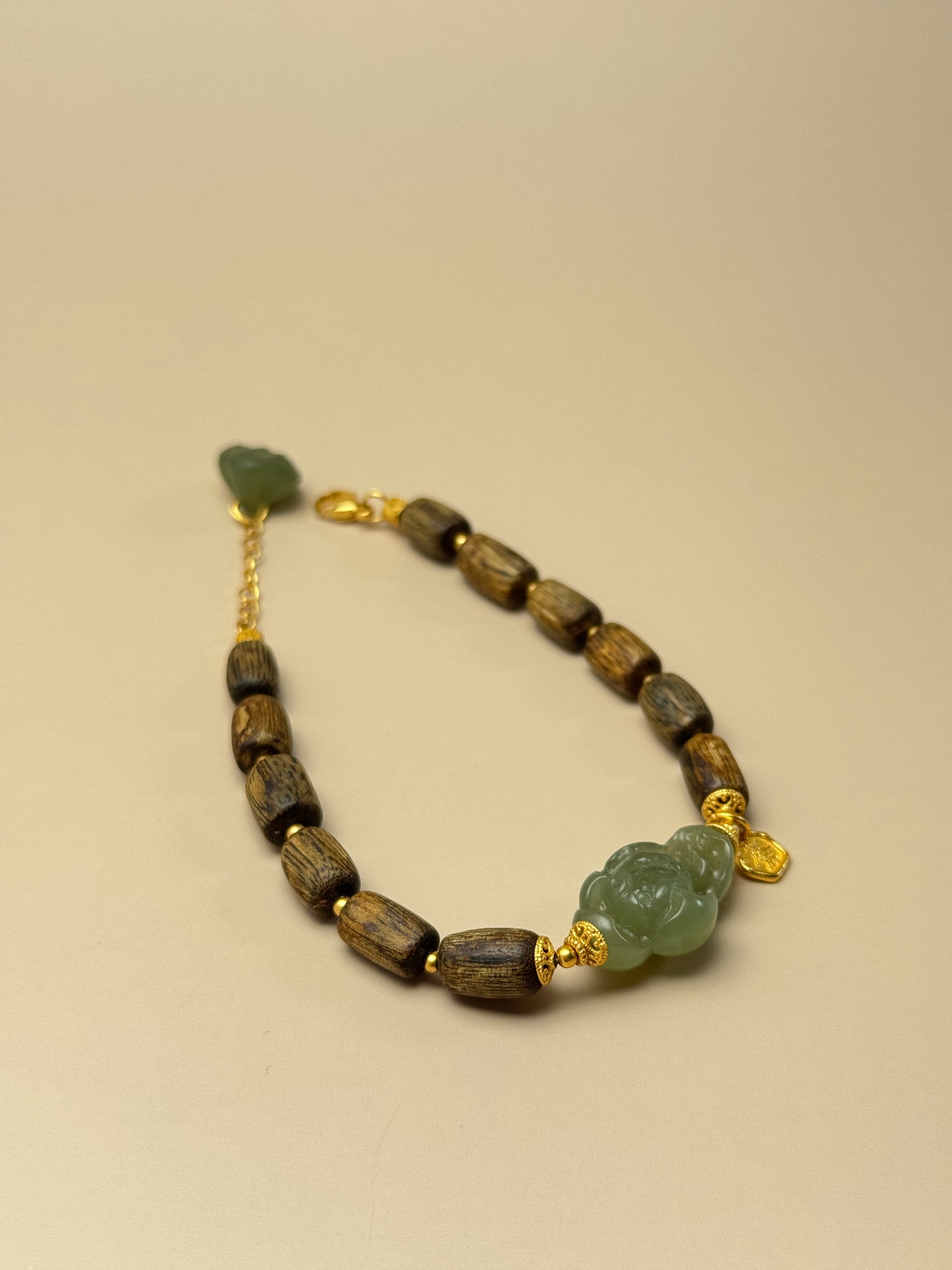 Feng shui bracelet made of natural agarwood and Hetian jade with lotus charm, supports heart chakra and emotional healing.