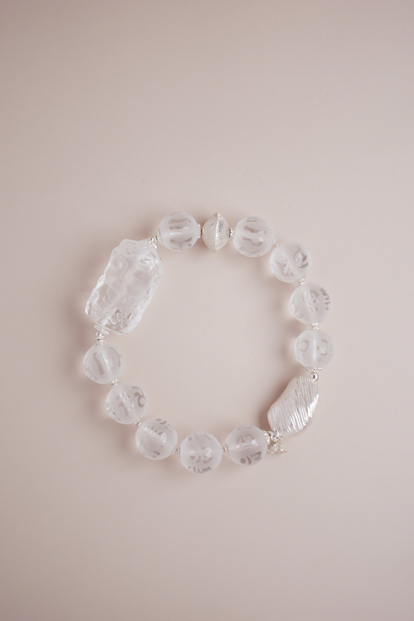 Frosted clear quartz bracelet with Om Mani Padme Hum engraving and carved Baby Tara charm on brushed S925 sterling silver.