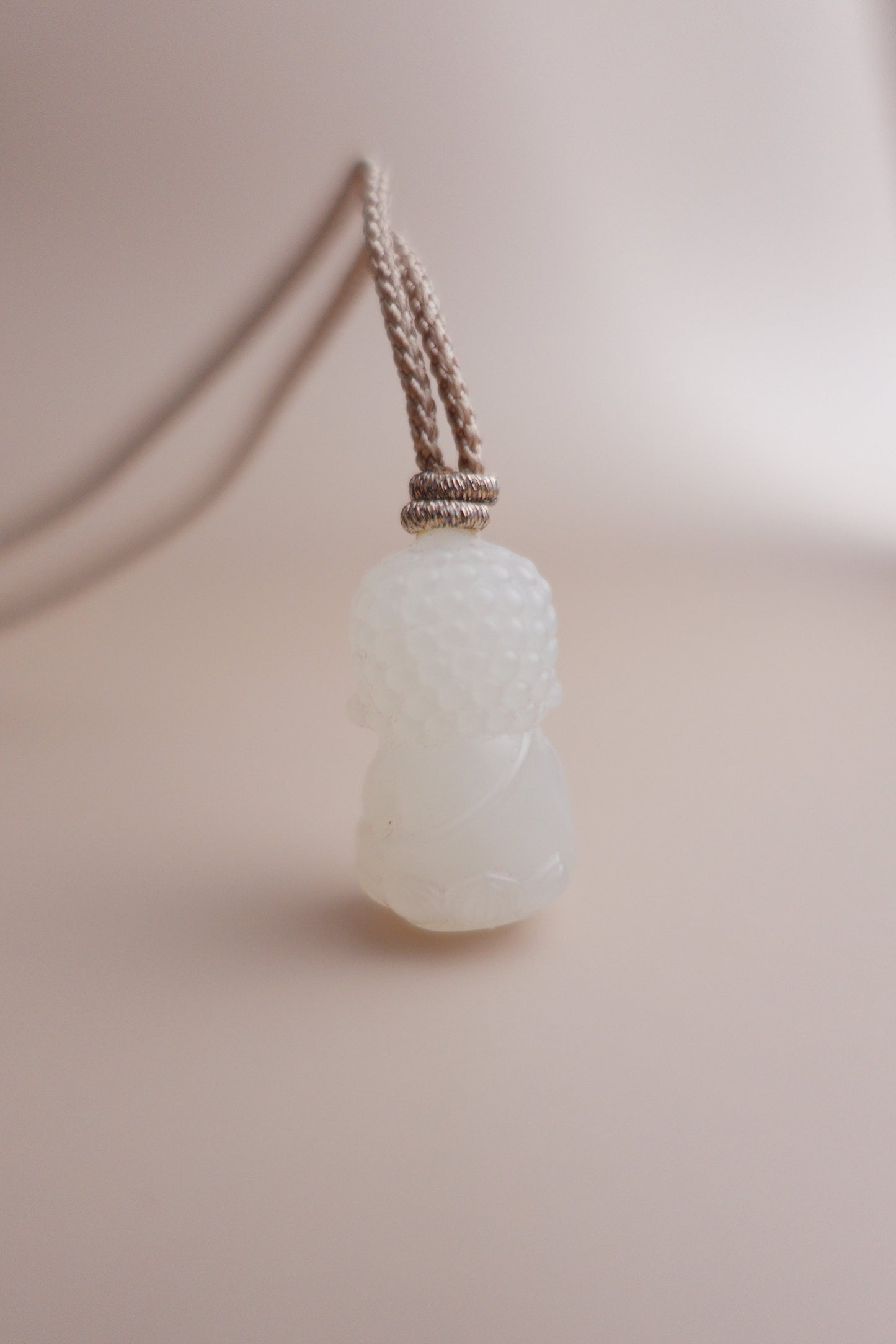 Handcrafted Between Dust necklace with premium white jade Baby Buddha pendant and adjustable braided cord.