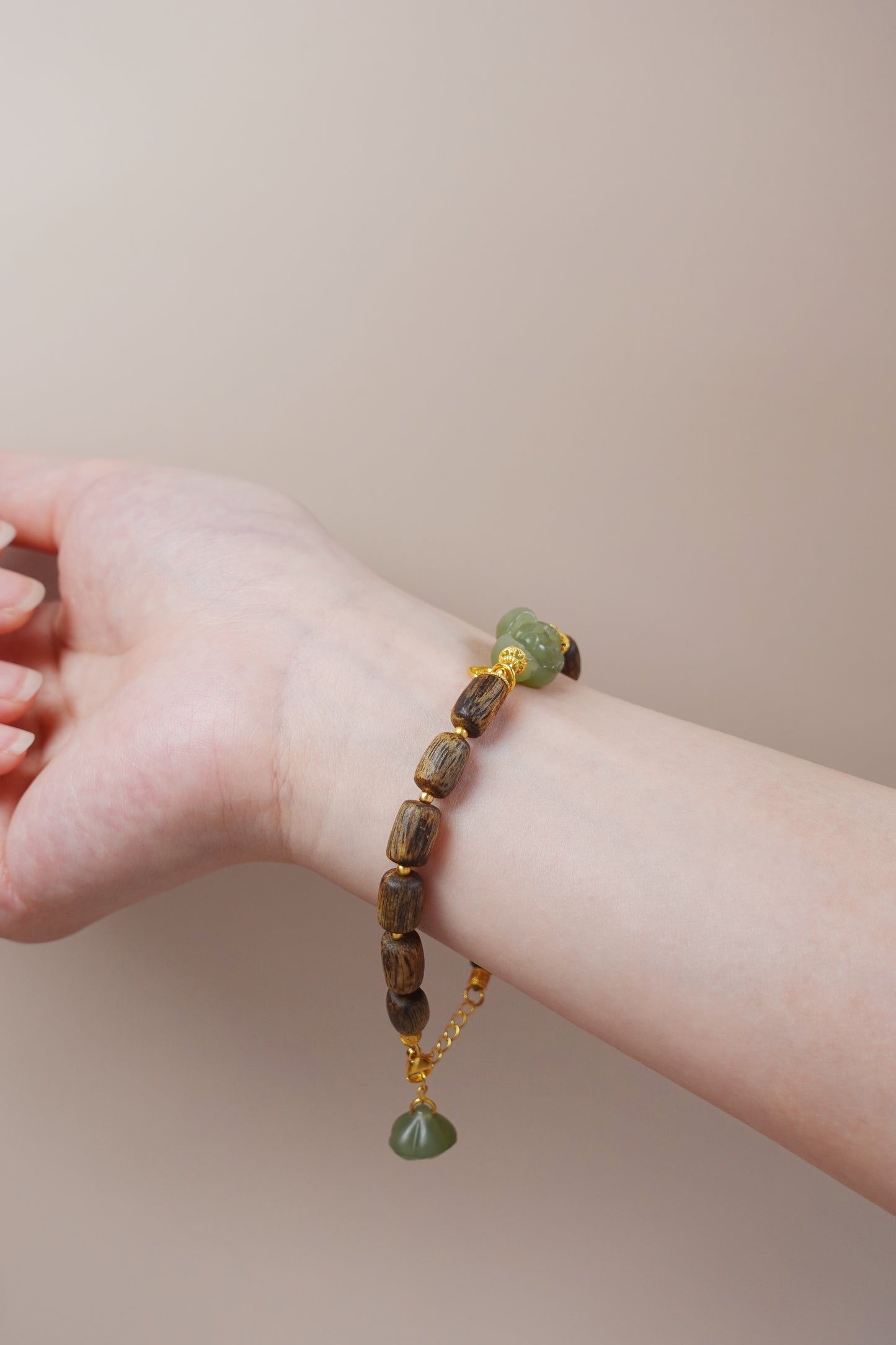 Close-up of Hetian jade lotus charm with gold vermeil detailing, symbolizing purity and spiritual growth