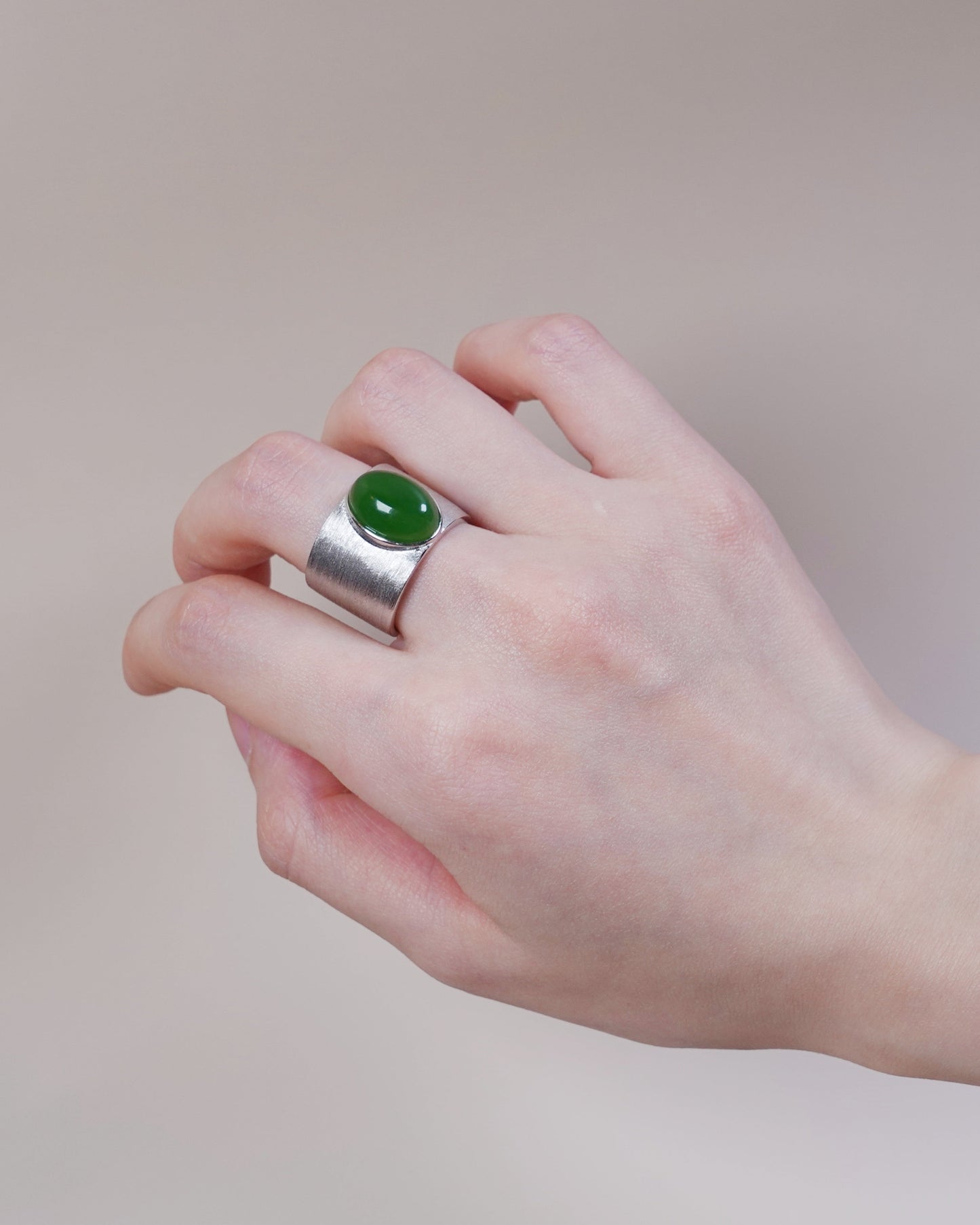 Hand wearing silver and white jade ring, Heart Chakra inspired grounding jewelry