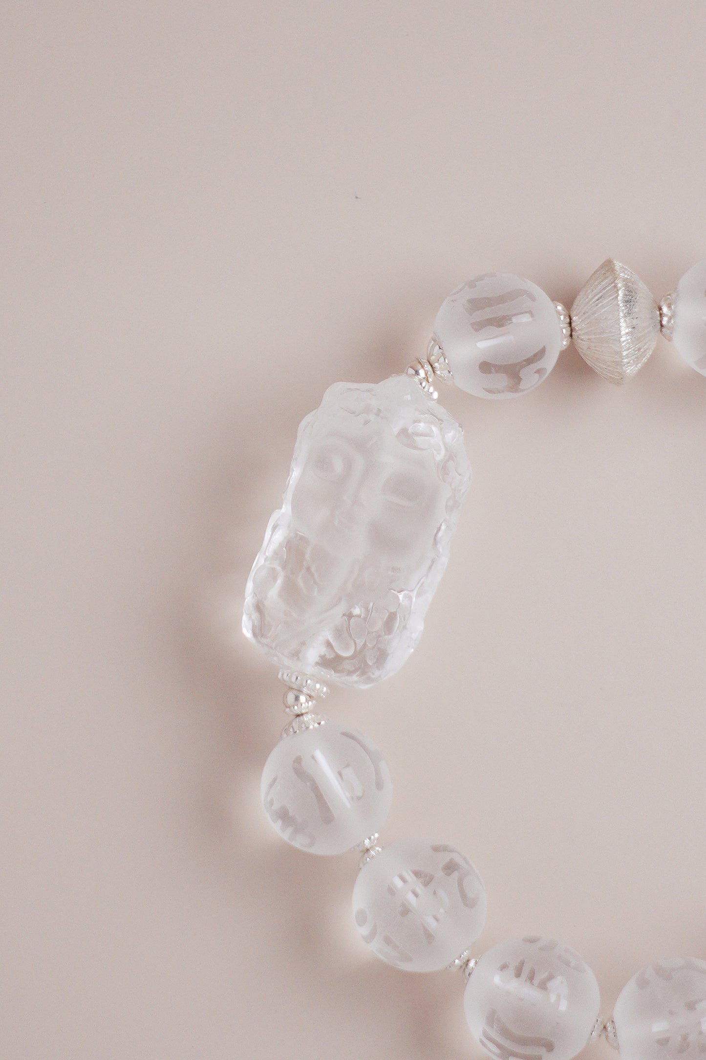 Om Mani Padme Hum mantra quartz bracelet featuring 10 mm frosted beads and Baby Tara carving with silver spacers.
