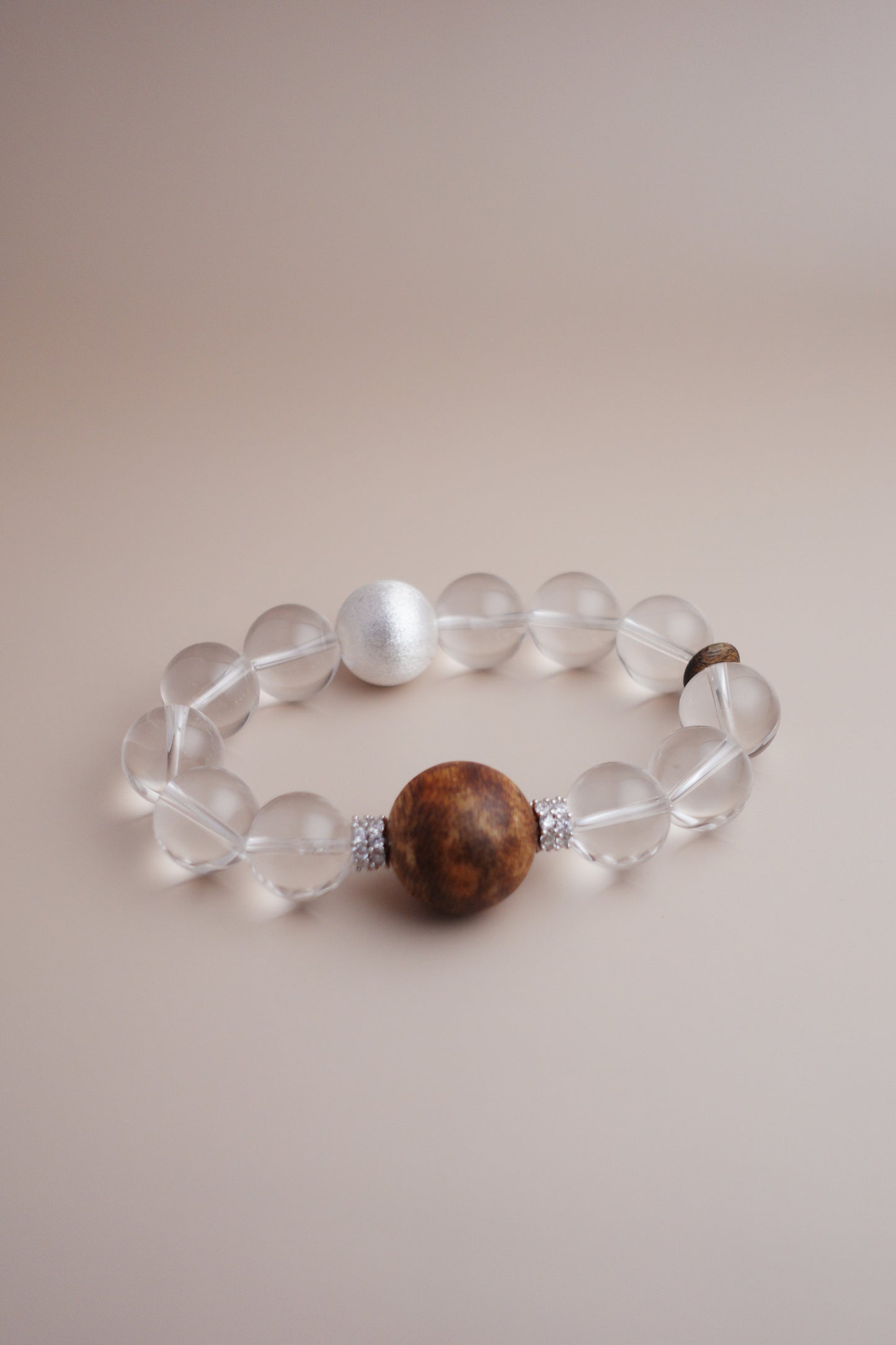 Artisan bracelet featuring clear quartz, Hainan agarwood, and brushed sterling silver spacer beads.