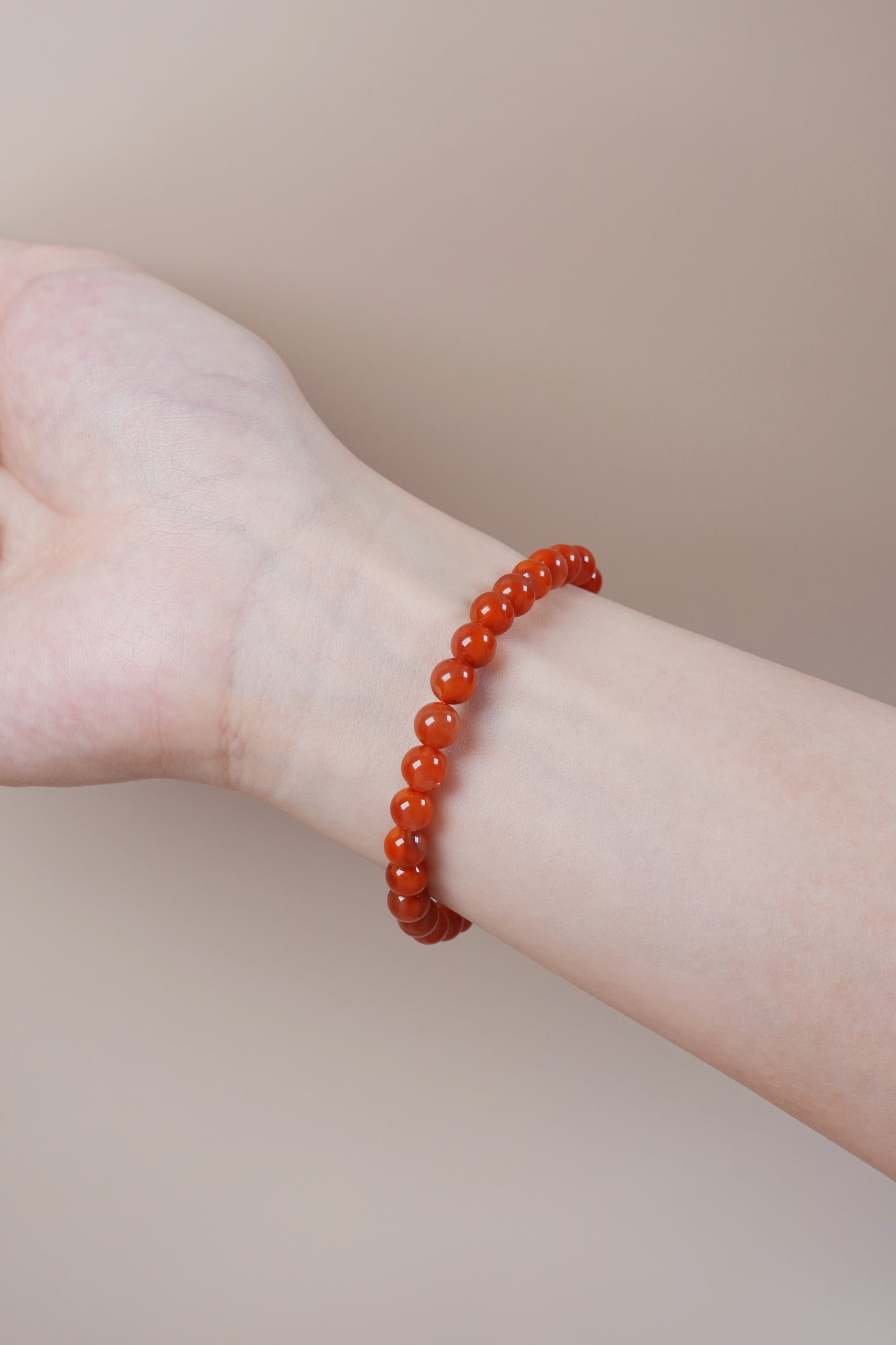 Wrist wearing red agate flame bracelet, Root Chakra gemstone for passion and grounding