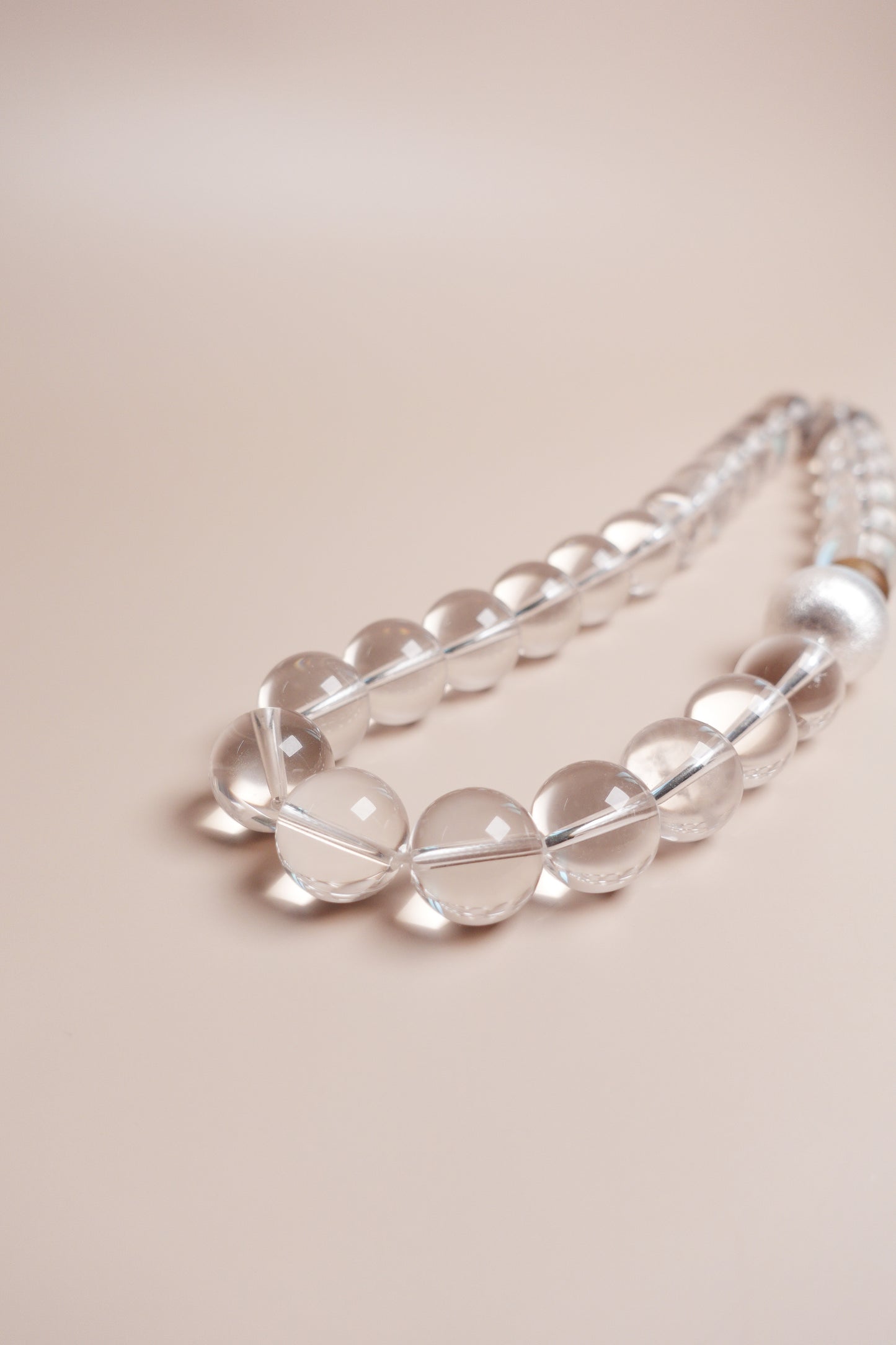 Clear beaded necklace on a beige background