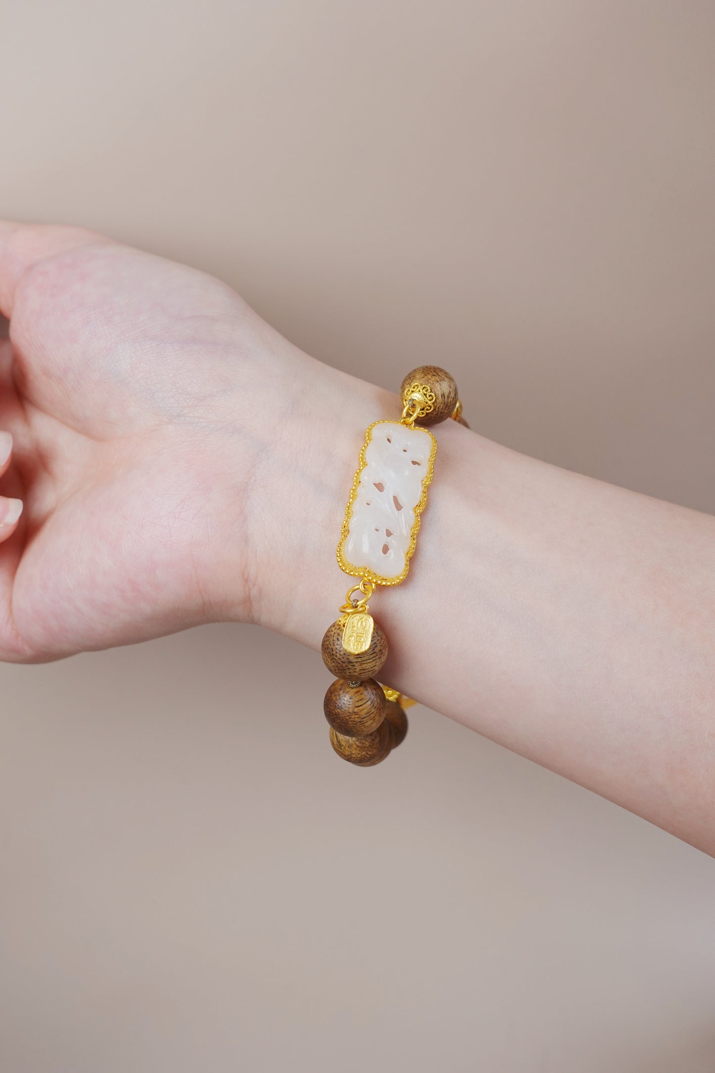 Model wearing agarwood and white jade bracelet, natural gemstone piece for emotional clarity. Close-up of floral white jade plaque with soft curves, symbolizing renewal and feminine energy