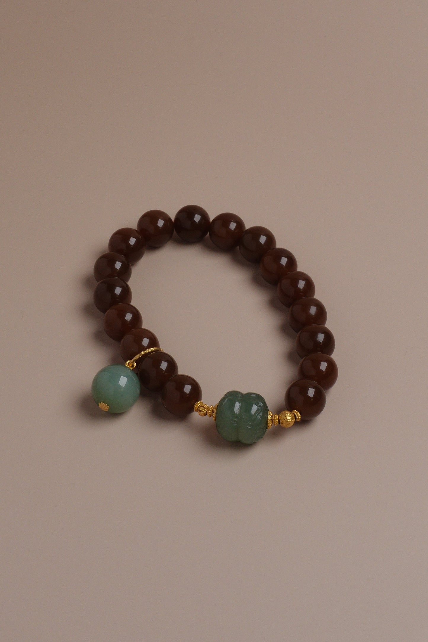 Autumn Grove Bracelet with caramel brown and celadon green Hetian jade beads accented by 18K gold on a neutral background