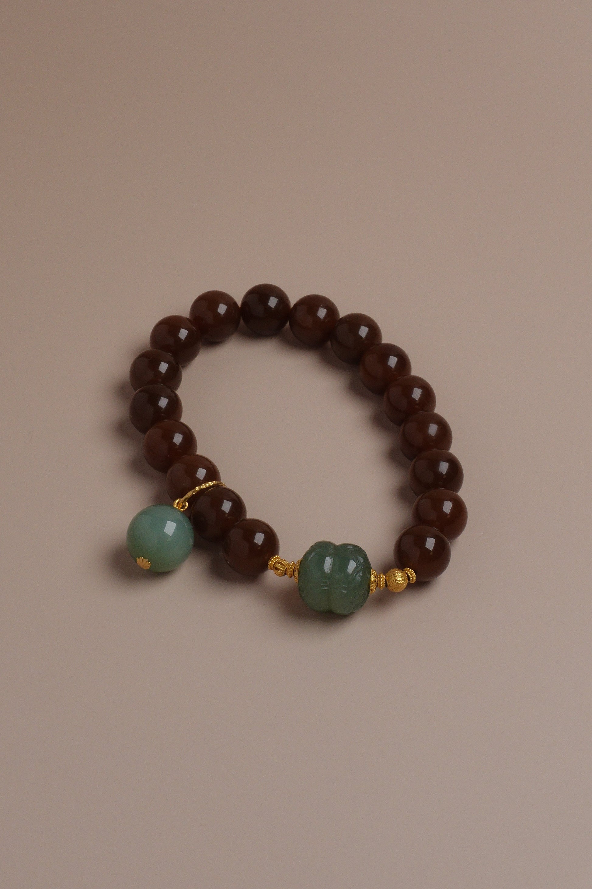 Autumn Grove Bracelet with caramel brown and celadon green Hetian jade beads accented by 18K gold on a neutral background