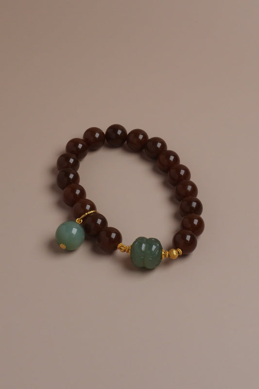 Autumn Grove Bracelet with caramel brown and celadon green Hetian jade beads accented by 18K gold on a neutral background