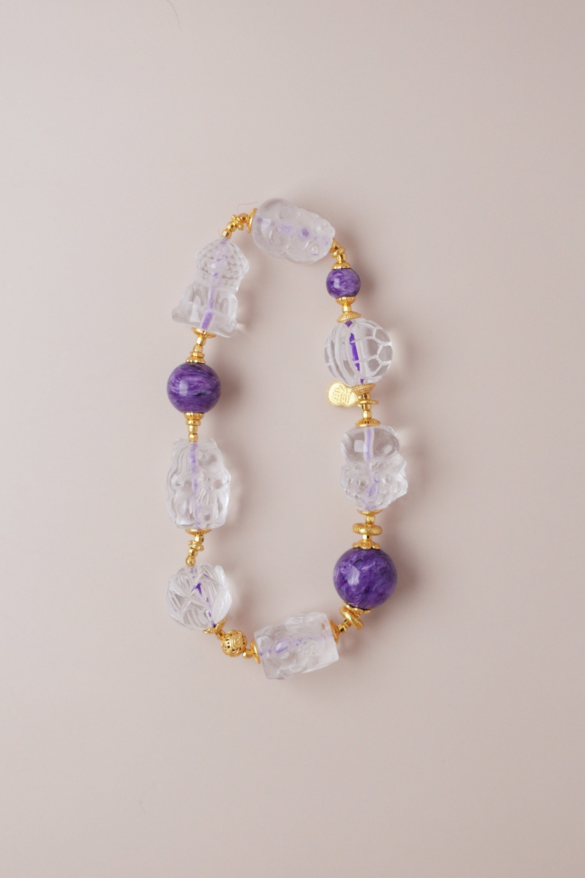 Charoite and clear quartz bracelet featuring Pixiu, nine‑tailed fox, lotus, koi, turtle shell, baby Buddha, and Tara carved charms