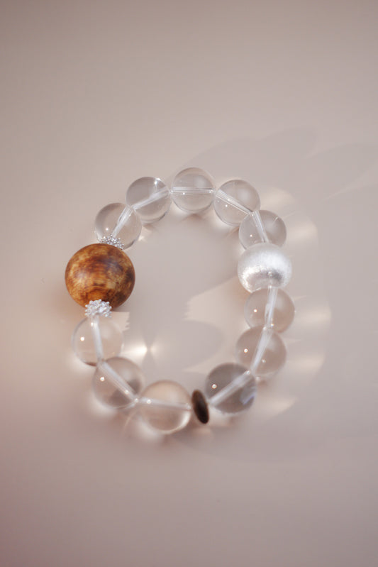 Tranquil Essence bracelet with 15 mm clear quartz beads and a 20 mm Hainan Chenxiang focal bead on stretch cord.