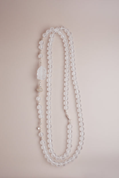 Frosted clear quartz mala necklace with Om Mani Padme Hum engraving and carved Baby Ganesha charm on silver accents.