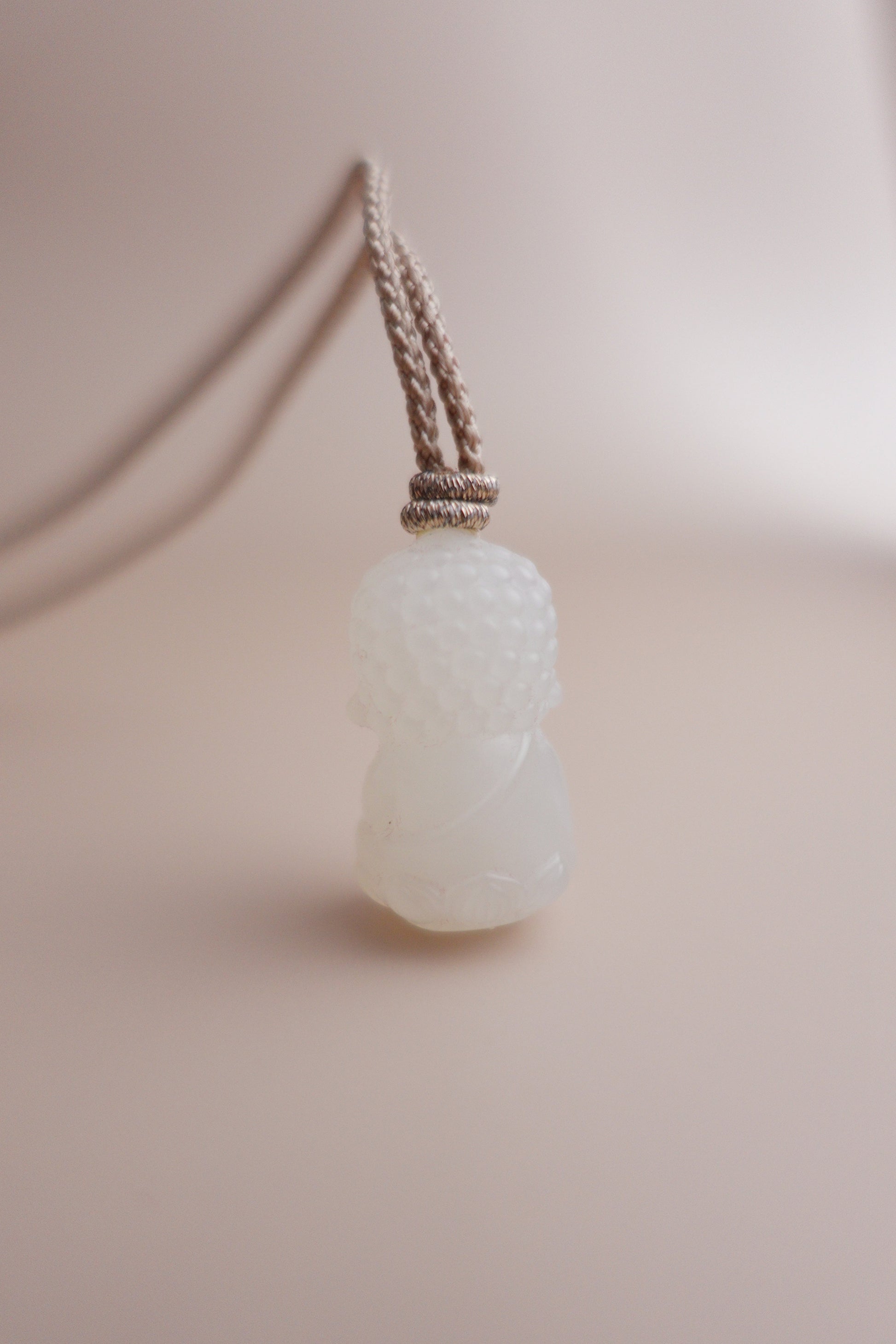 Handcrafted Between Dust necklace with premium white jade Baby Buddha pendant and adjustable braided cord.