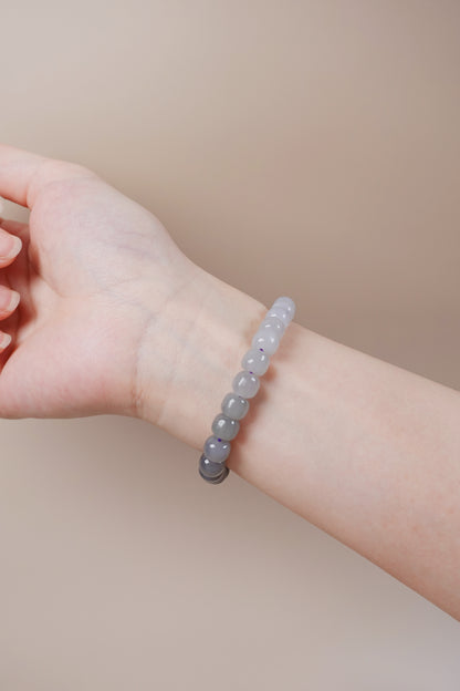 Wrist wearing smoky purple jade bracelet, calming energy jewelry linked to Metal and Water elements
