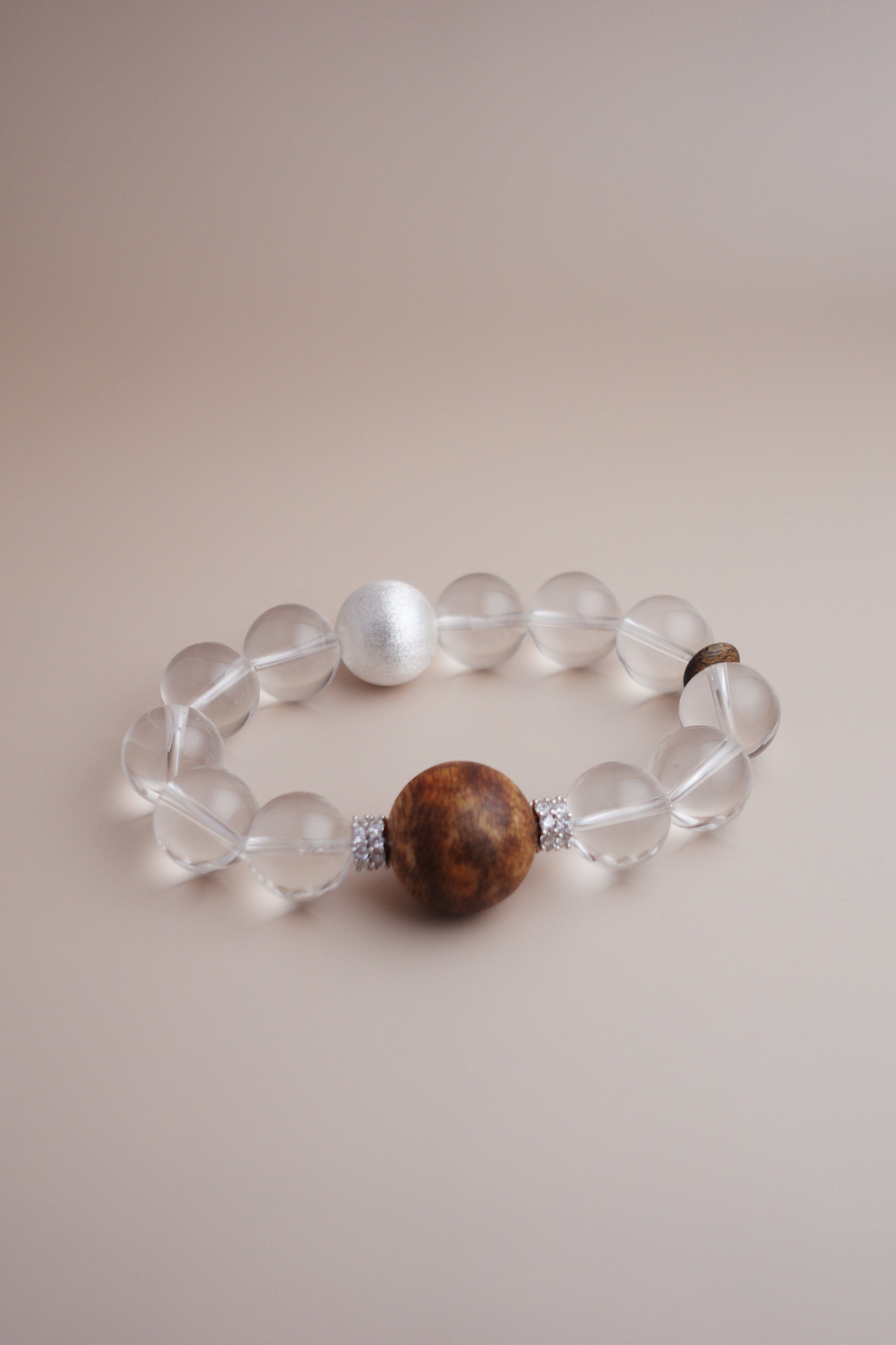 Artisan bracelet featuring clear quartz, Hainan agarwood, and brushed sterling silver spacer beads.