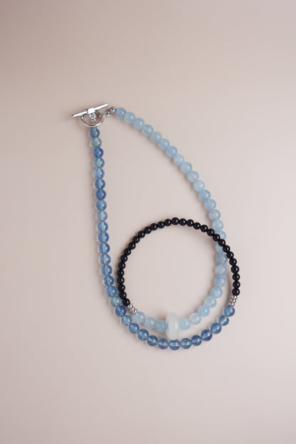 Seaside Dusk gradient necklace of deep and light aquamarine beads paired with black onyx