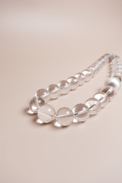 Clear beaded necklace on a beige background